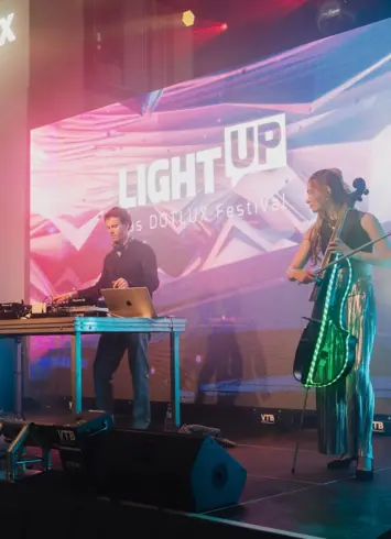 Ein DJ und eine Cello spielende Frau auf einer Bühne