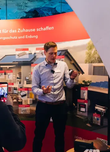 Ein Mann an einem Messestand, der Produkte erklärt